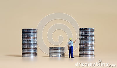 Business concept with a miniature person with a pile of coins. Stock Photo