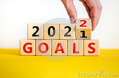 Business concept of planning 2022 goals symbol. Businesman turns a wooden cube and changes words `Goals 2021` to `Goals 2022`. Stock Photo