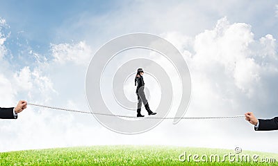 Business concept of risk support and assistance with man balancing on rope Stock Photo