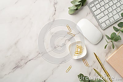 Business concept. Top view photo of workstation keyboard pink reminder stationery gold pens clips computer mouse and eucalyptus on Stock Photo