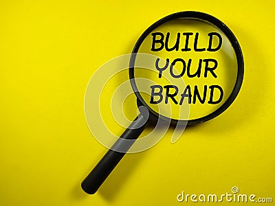 Business concept.Word BUILD YOUR BRAND on yellow background Stock Photo