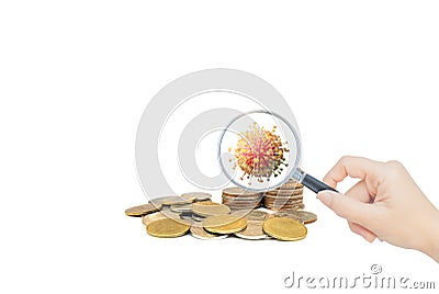 Hand holding magnifying glass and inspecting stacked coins. Stock Photo