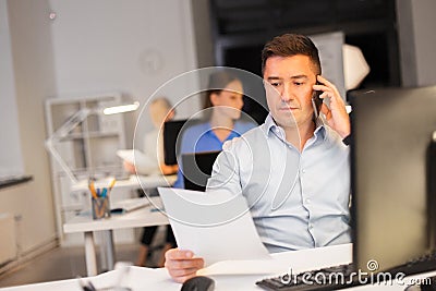 Man calling on smartphone at night office Stock Photo