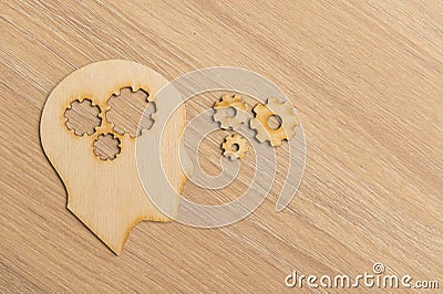 Business and design concept - wooden man head silhouette with gear icon on wooden background Stock Photo