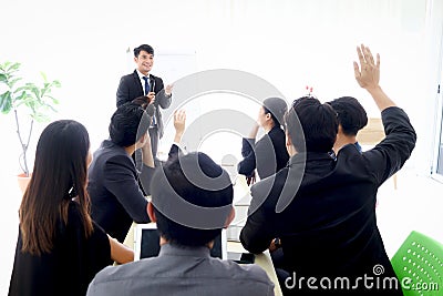 Business discussing at conference office desk, speaker having presentation, businesspeople raising hand up to ask question at Stock Photo