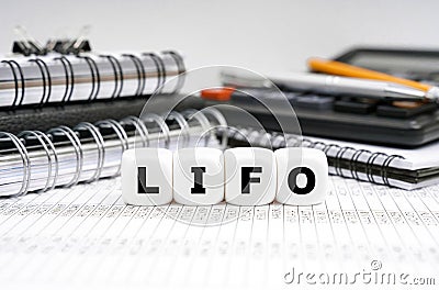 On the table, among office objects, cubes with the inscription - LIFO Stock Photo