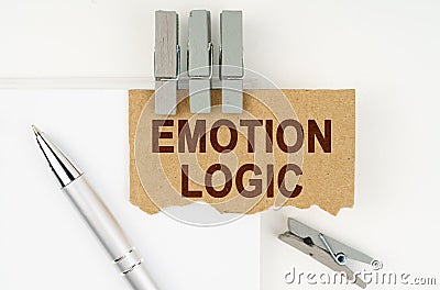 On a white background lies a notebook, a pen, clothespins and cardboard with the inscription - Emotion Logic Stock Photo