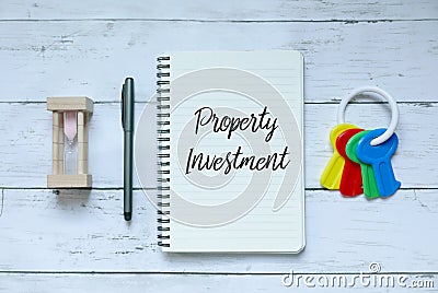 Business,finance and property concept. Top view of sand clock,pen,keys and notebook written with Property Investment. Stock Photo