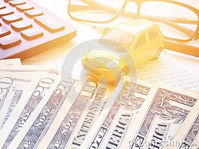 Miniature car model, American Dollars cash money, calculator and saving account book or financial statement on office desk table Stock Photo