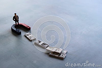 Selective focus image of miniature businessman attracts money using magnet Stock Photo