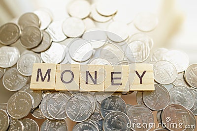 Business and Financial Concept. Top view of letter wooden block wording MONEY on pile of Thailand, Thai Baht coins Stock Photo