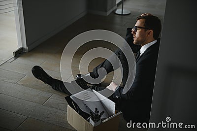 business, firing and job loss concept - fired male office worker with box of his personal stuff. Stock Photo