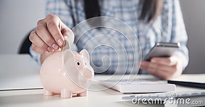 Business girl putting coin in a piggy bank. Saving money Stock Photo