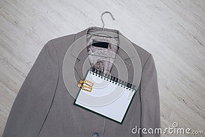 Business gray jacket on a hanger with sunglasses and a notebook Stock Photo