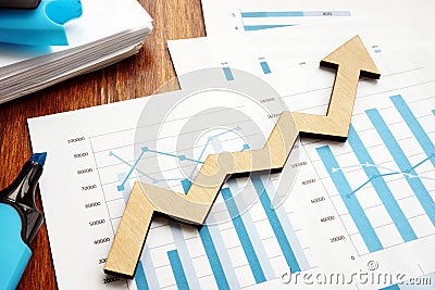 Business growth. Wooden arrow and financial reports Stock Photo