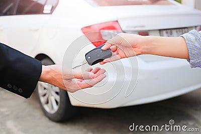 Business hand giving a key for buyer or rental car. Stock Photo