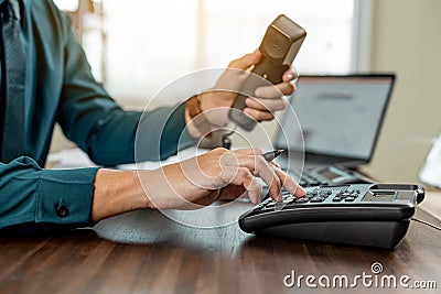 Business hands using telephone in office. Businessman dialing VoIP phone in the office Stock Photo