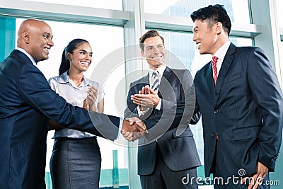 Business handshake in lofty office with city view Stock Photo