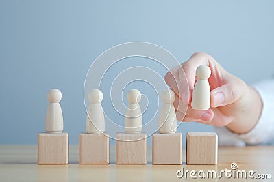 Hand Choose figure standing out from the group of crowd. Business hiring and recruitment selection concept. Stock Photo