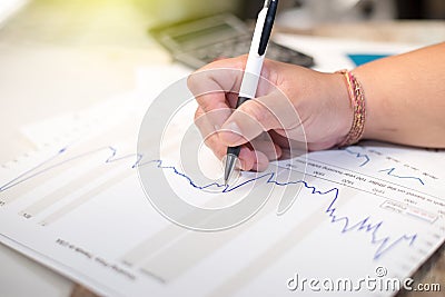 Business holding pen and think with chart and calculator Stock Photo