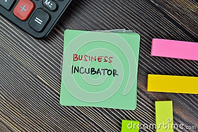 Business Incubator write on sticky notes isolated on Wooden Table Stock Photo