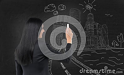 Business lady is drawing a sketch of Moscow International Business Centre, Moscow-city on the black chalkboard. Stock Photo