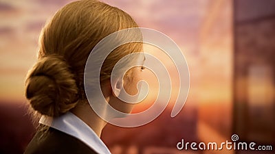 Business lady looking at sunset, dreaming of vacation, lack of time for trips Stock Photo