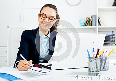 Business lady sitting at office desk with laptop Stock Photo