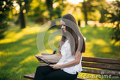 Business lady uses a tablet in the park during a break Stock Photo