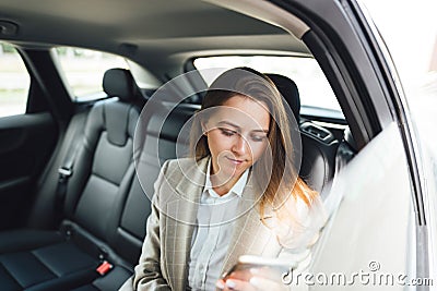 Business lady using smartphone while traveling by car Stock Photo