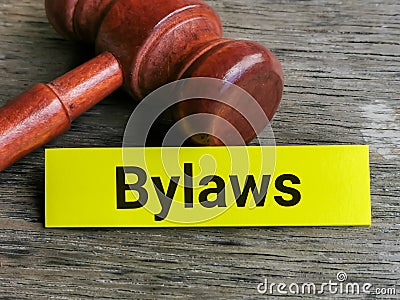 Phrase BYLAWS written on sticky note with gavel. Stock Photo