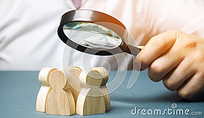 Business leader holding a magnifying glass over a team of workers. The concept of finding new employees. Teamliding. Team Stock Photo