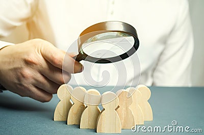 Business leader holding a magnifying glass over a team of workers. The concept of finding new employees. Teamliding. Team Stock Photo