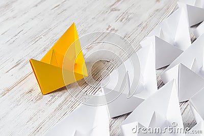 Business Leadership Concept With White And Color Paper Boats On Wooden Table