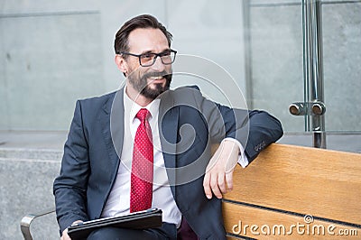 Business, Leisure, technology, communication and people concept-man with tablet on city street bench. Portrait of handsome man Stock Photo