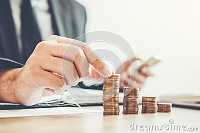 Business man Accounting Calculating Cost Economic budget putting Row and coin Write Finance ,investment and saving concept Stock Photo