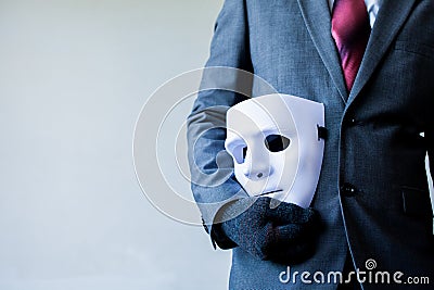 Business man carrying white mask to his body indicating Business fraud and faking business partnership Stock Photo