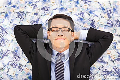 Business man enjoying and lying on the stacks of money Stock Photo