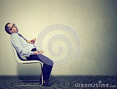 Business man feeling tired and sleepy after eating too many burgers for lunch Stock Photo