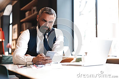 Business man in formal clothing using mobile phone. Serious businessman using smartphone at work Stock Photo