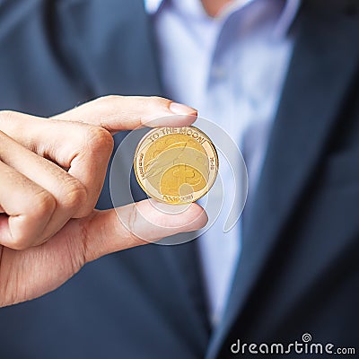 Business man hand holding gold Dogecoin cryptocurrency, Crypto is Digital Money within the blockchain network, is exchanged using Editorial Stock Photo