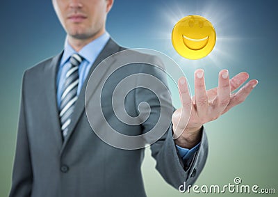 Business man with hand out and emoji with flare against blue green background Stock Photo