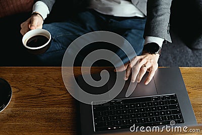 Business man hands working on laptop holding cup of coffee Editorial Stock Photo