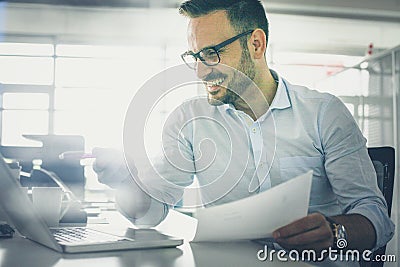 Business man holding document and checking e mail on laptop. Stock Photo