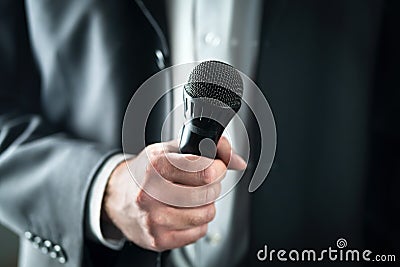 Business man holding microphone. Public speaking and giving speech in suit for audience concept. Stock Photo