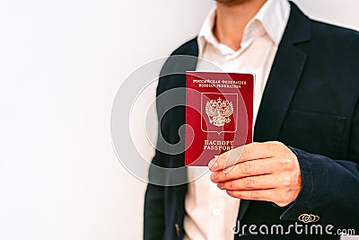 A business man in a jacket and shirt holds a Russian passport Stock Photo