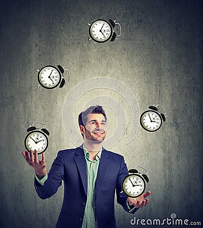 Business man juggling his time alarm clocks Stock Photo