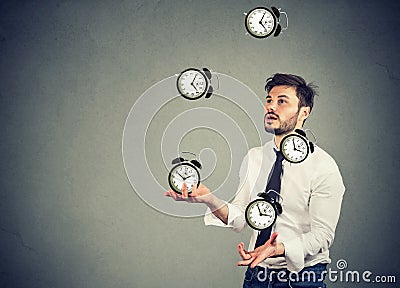 Business man juggling his time alarm clocks Stock Photo