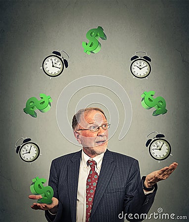 Business man juggling multiple alarm clocks and dollar sings Stock Photo