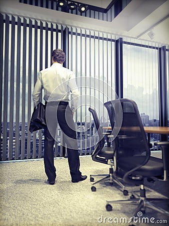 Business man looking on city through an office window Stock Photo